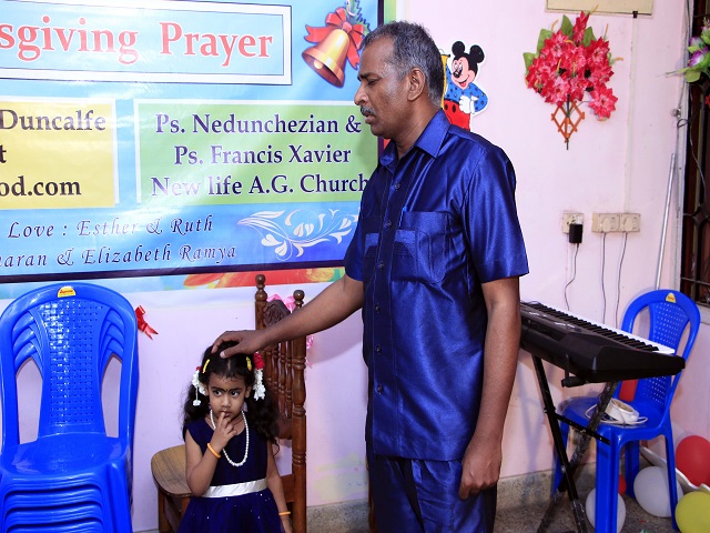 Tamil praying for a little girl.