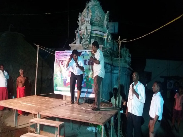 Tamil and his Pastor preaching in a village in India.